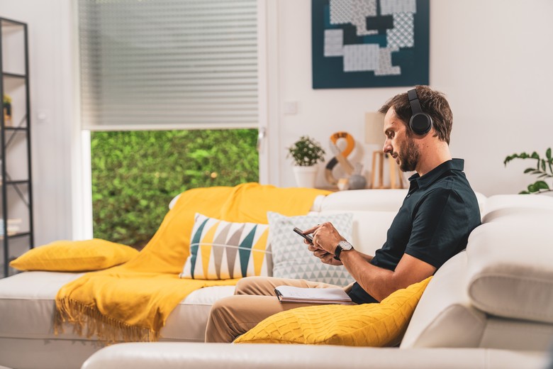 somfy-legrand-man-holding-smartphone-in-living-room